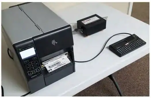 Zebra industrial printer connected to the black box and a Zebra keyboard display unit on a table