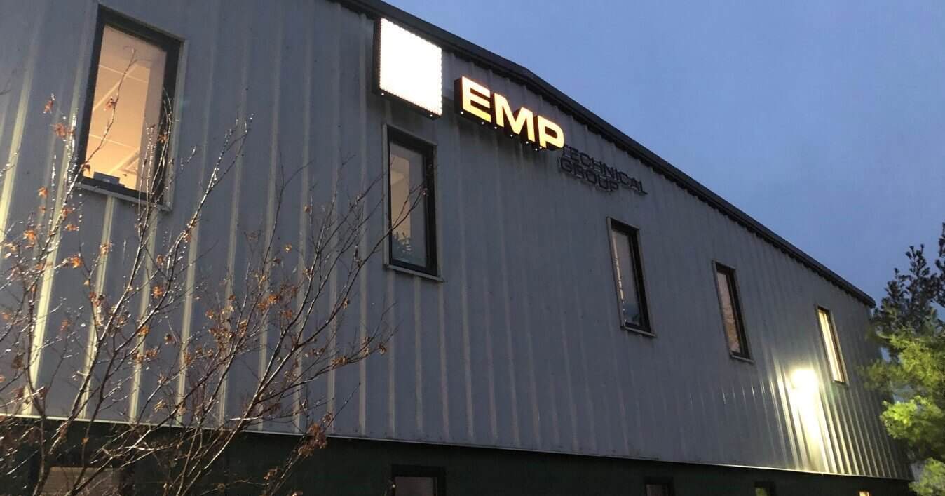 Exterior of the EMP Technical Group building at dusk with the lit EMP sign