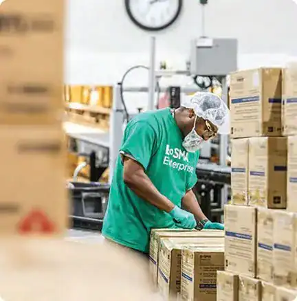 Bosma Enterprises worker in a green shirt packing boxes on a production line