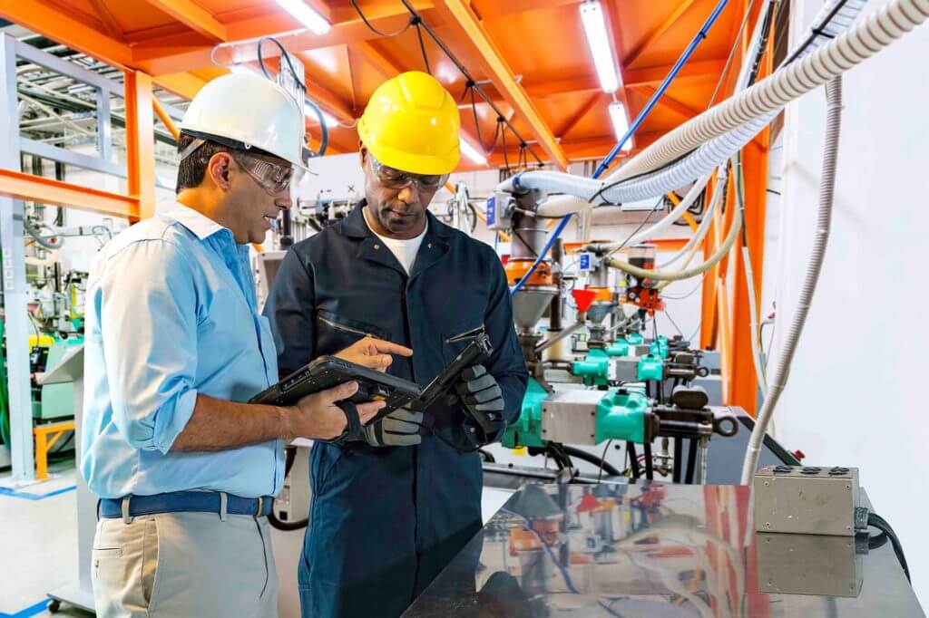 Workers using mobile computers on shop floor