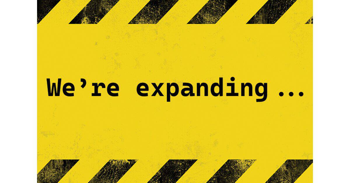 Yellow and black caution-striped sign reading We're expanding