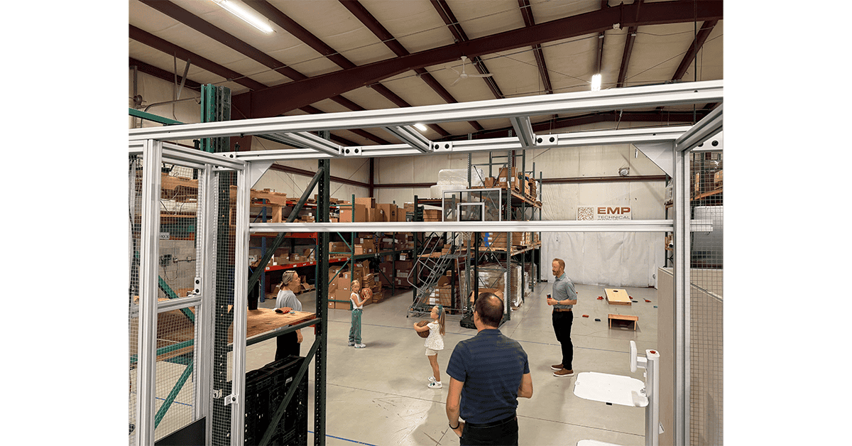 EMP employees and families playing cornhole in the warehouse during a company party
