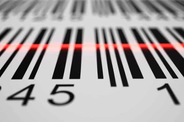 Close-up of a barcode being read by a red scanner beam