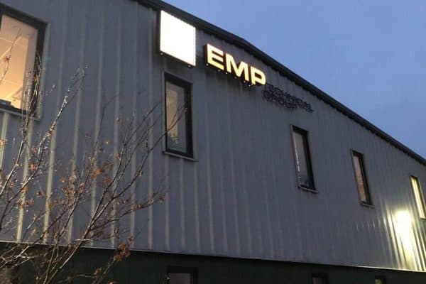 Exterior of the EMP Technical Group building at dusk with the lit EMP sign