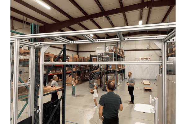 EMP employees and families playing cornhole in the warehouse during a company party