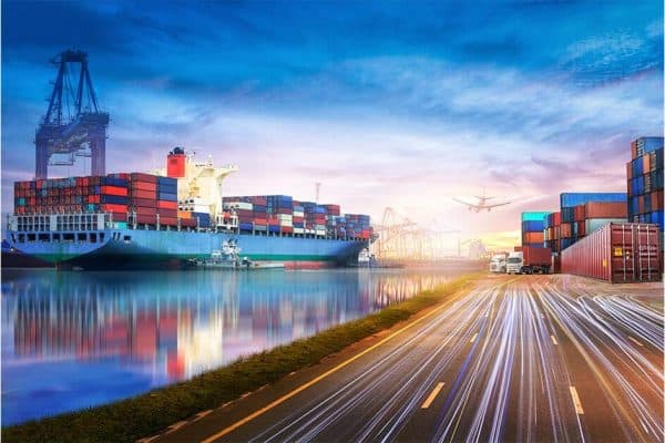 A sea port with supply tankers, airplanes, cargo containers, and trucks