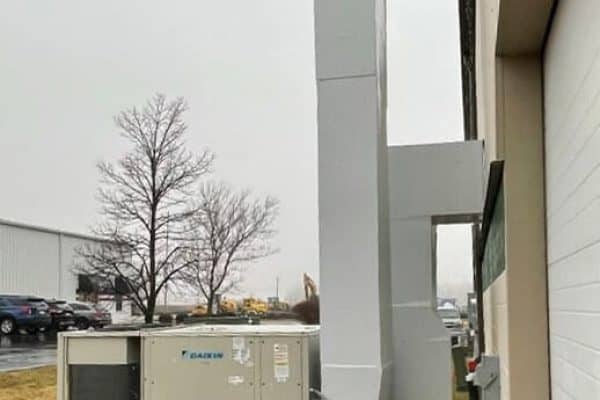 New rooftop HVAC unit and ductwork installed on the outside wall of the EMP building