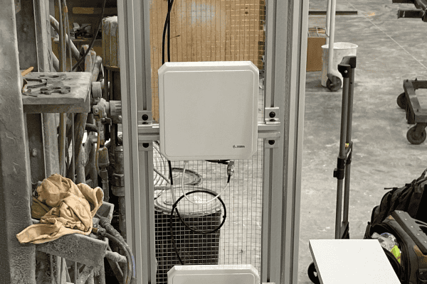 Aluminum-frame RFID reader stand with a Zebra fixed reader and two antennas in a wood products plant