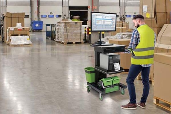 Worker using powered labeling cart in warehouse